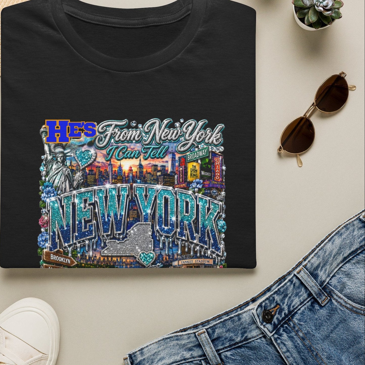 Black t-shirt with 'Hers From New York' design on a light surface with accessories.