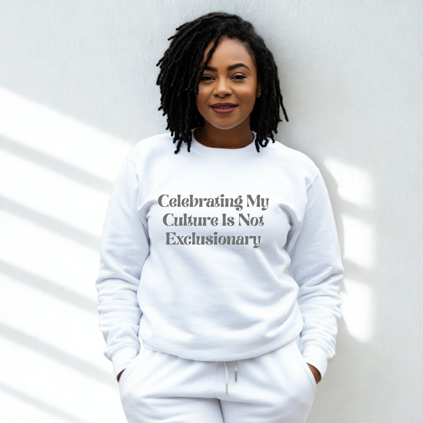 Person wearing a white sweatshirt with text, standing against a light background